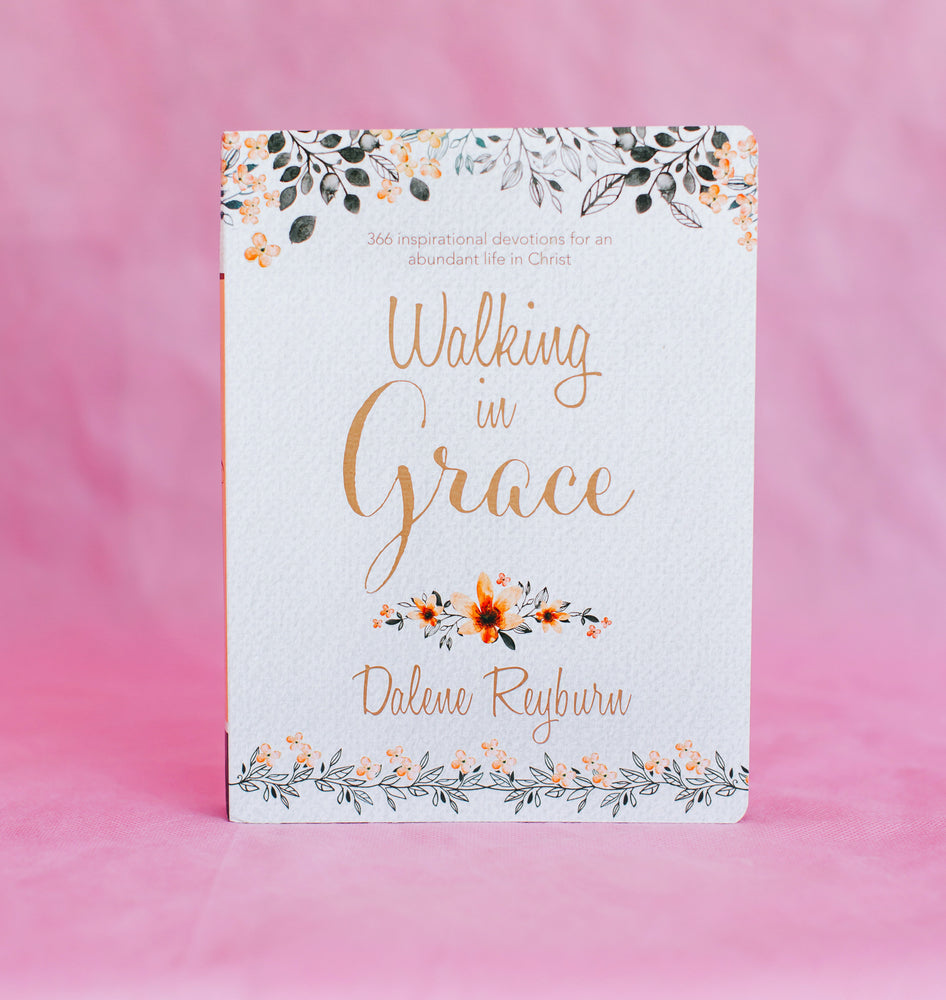 Front View of Front View of Grey with Navy and Pink Floral Detailing and Rose Gold Lettering Book In Front of Pink Backdrop-Walking in Grace 366 Inspirational Devotions For An Abundant Life In Christ